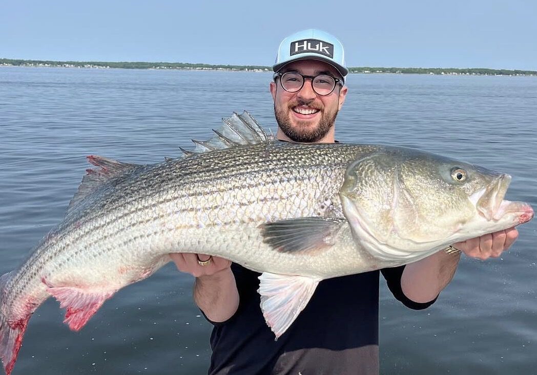 Man holding large fish on a boat.